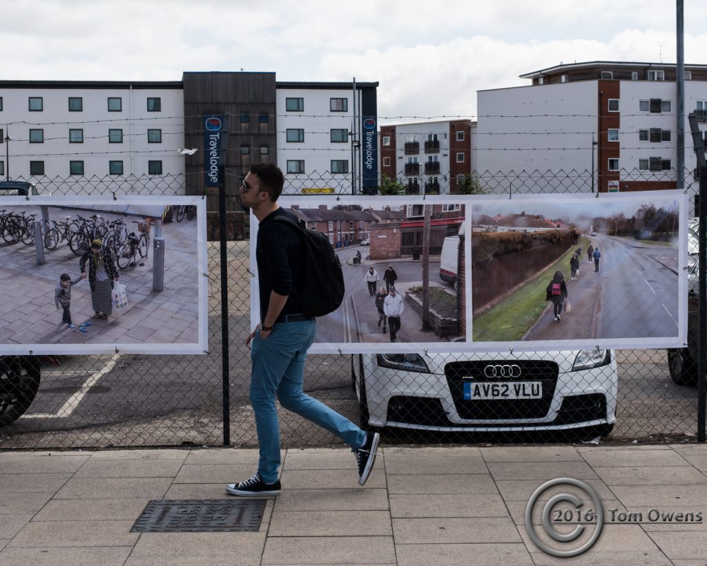 man walking past photos