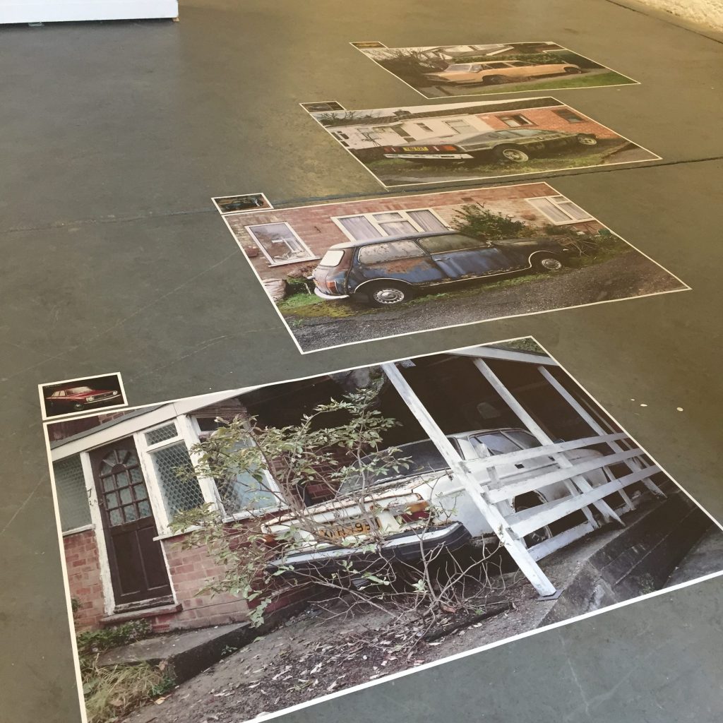 Rusty old car photographs stuck to the floor