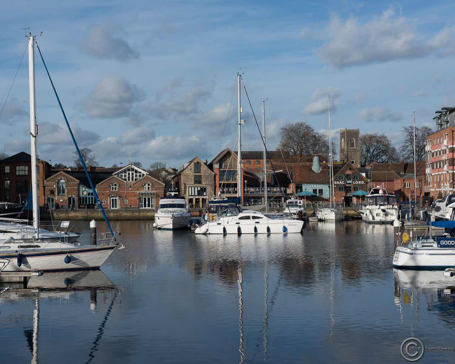 Boats and dock with buildings on distant quay