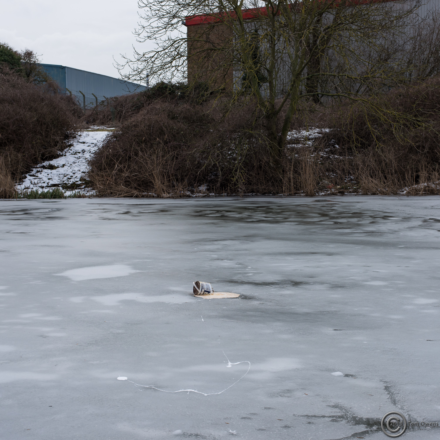Leaking paint tin on river ice